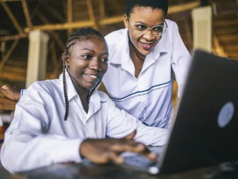 Two young women working on laptop